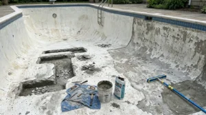 Close up of cracked and deteriorated swimming pool plaster surface needing repair