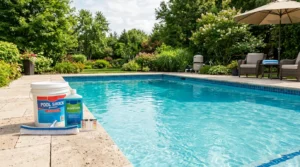 Pool shock bucket and algaecide bottle beside backyard pool